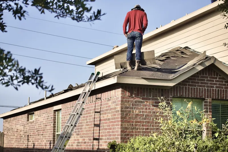 Professional roofer working on a residential roof in North Broadway